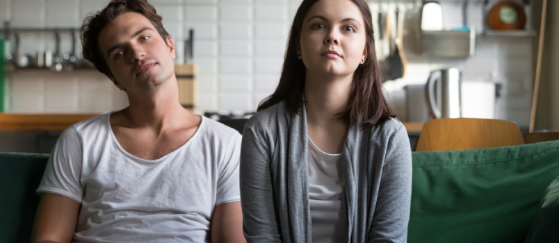 Lazy Millennial Couple Getting Bored at Home Sitting on Sofa