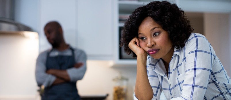Sad couple in kitchen at home