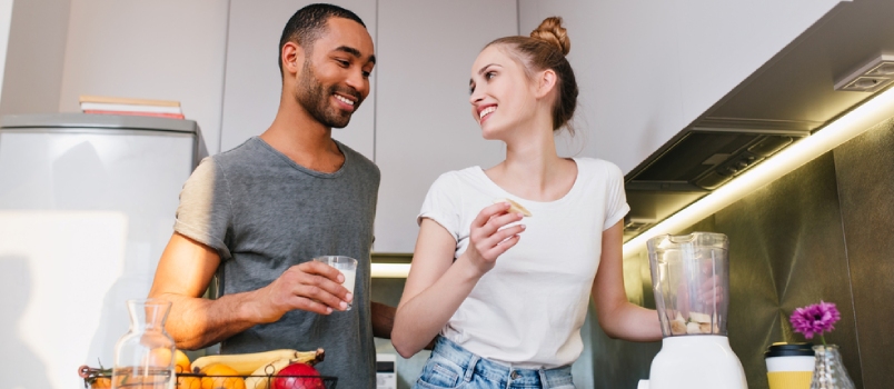 Couple in Home Clothes in Kitchen Talking With Happy Faces