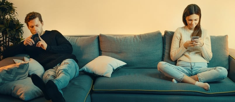 Smartphone Addicted Couple Use Phones Sit on Sofa at Home