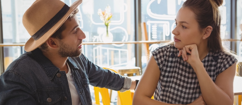 Young couple talking at table in cafe