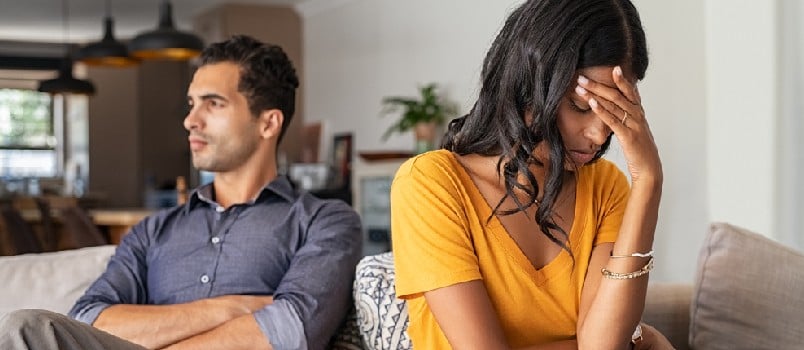 Middle eastern young couple sitting on couch after a fight