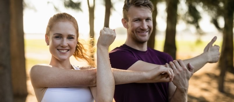 couple doing yoga together outdoor at the garden or park