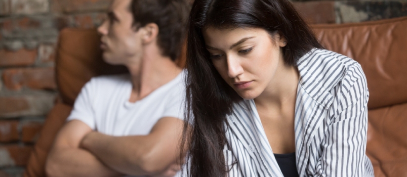 Sad upset men and women are sitting together at home on couch