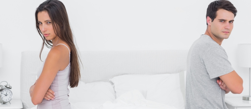 sad men and women sitting apart at bedroom on bed