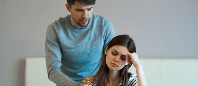 A young couple in a bedroom conflict displeasure and frustrated quarrel
