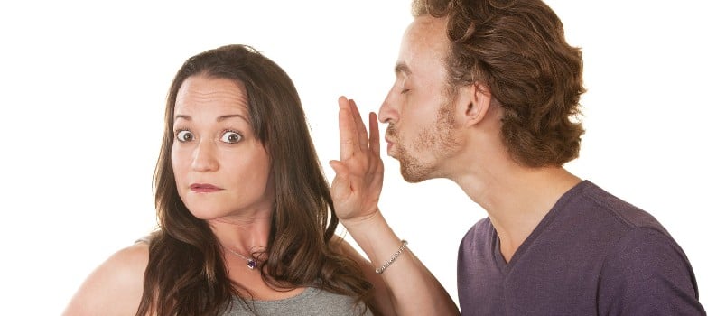 Unhappy woman blocking bearded man's kiss over white background