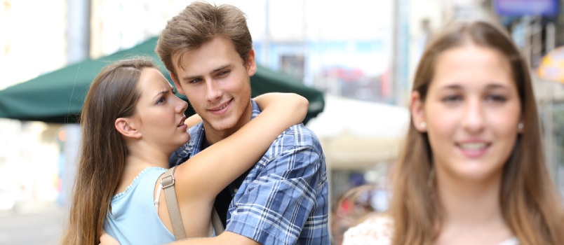 Unfaithful Man Hugging His Girlfriend While Stocking Other Girl