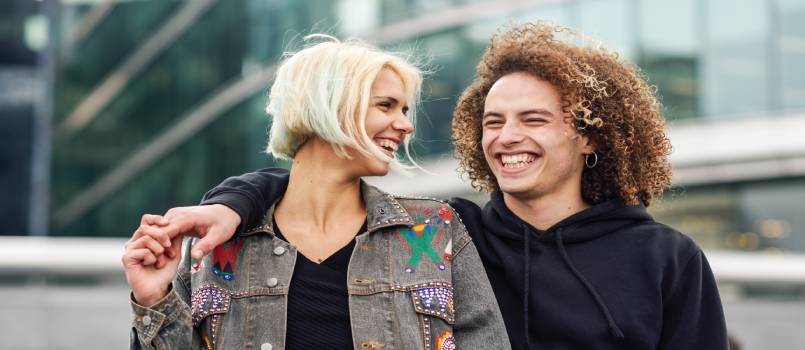 Happy young couple laughing in urban background