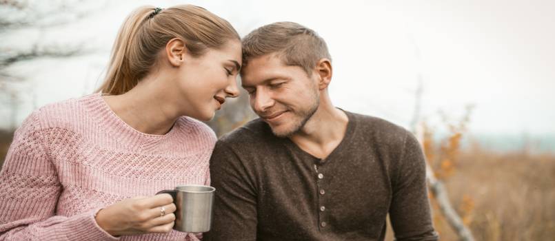 happy couple in love touched their foreheads in nature