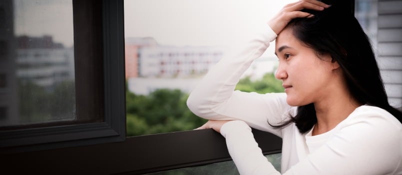 Depressed women siting near window
