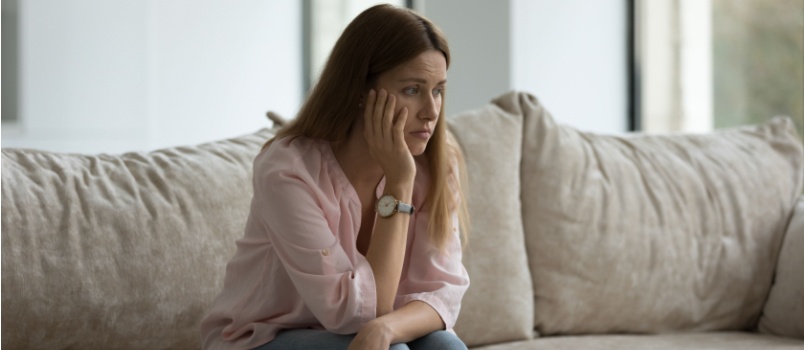 Sad woman sitting on couch