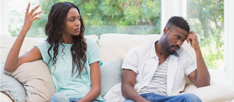 Young couple having argument sitting on couch