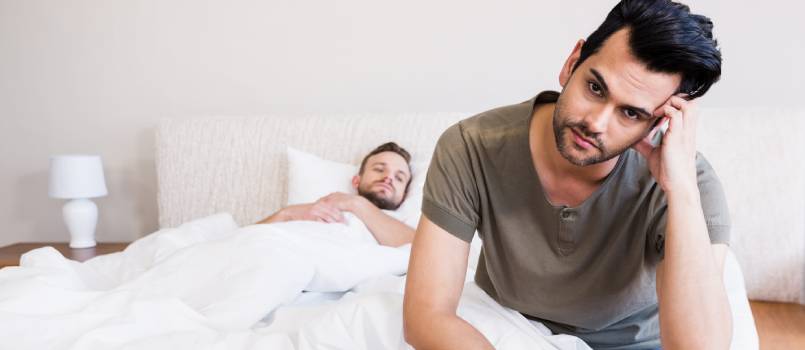 Thoughtful man sitting on bed
