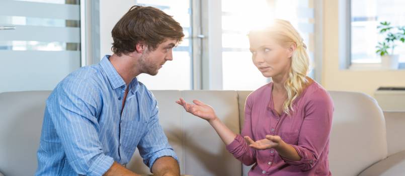Unsmiling couple talking to each other