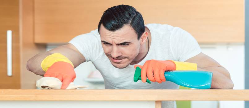 man is very diligent dusting and cleaning the kitchen