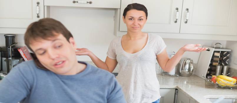Man talking on phone while women is wondering