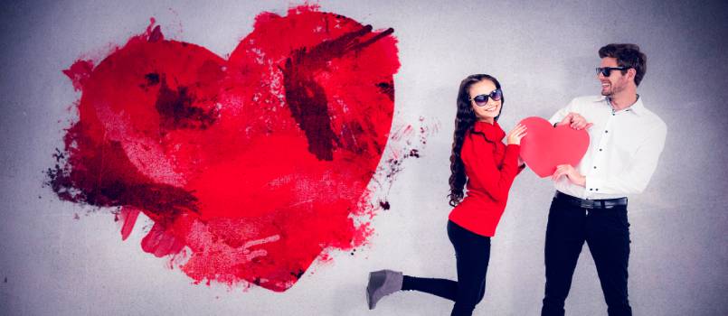 Smiling couple holding paper heart