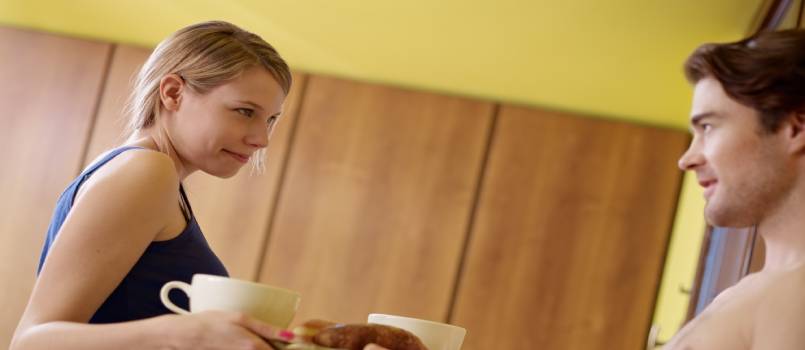 Young couple having breakfast on bed