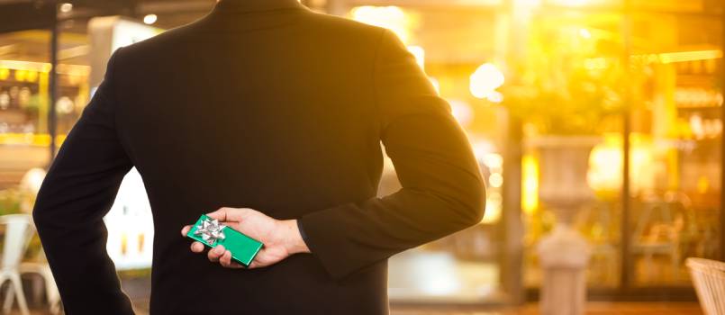 Man hiding gift in his hand
