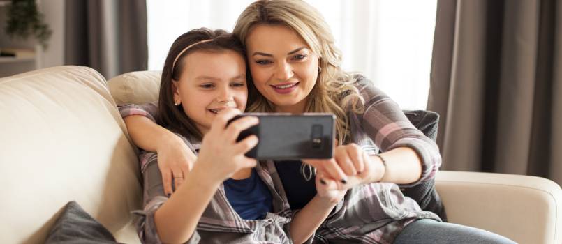 Mother and daughter using mobile phone