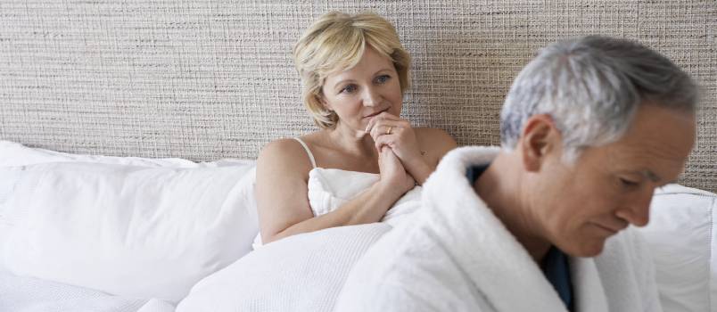 Unhappy middle aged couple in bedroom