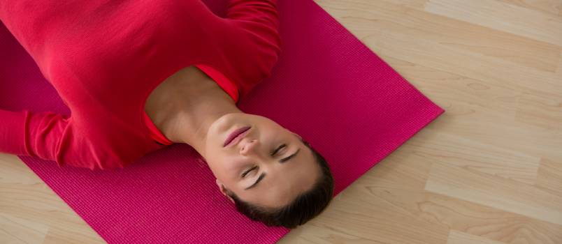 Woman laying on yoga mat