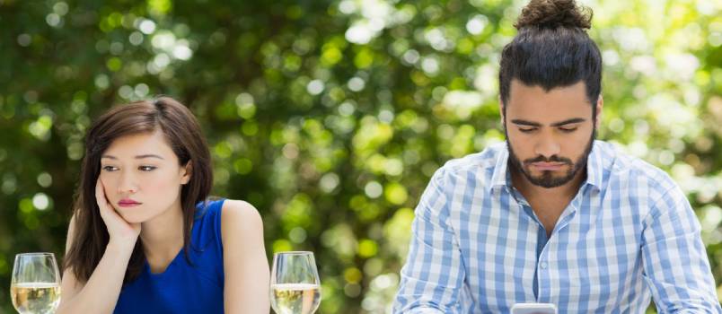 Man ignoring woman using mobile phone