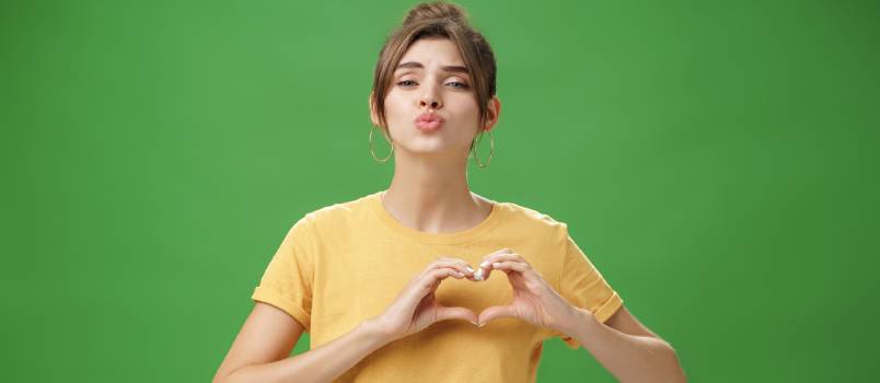 Charming woman showing heart gesture