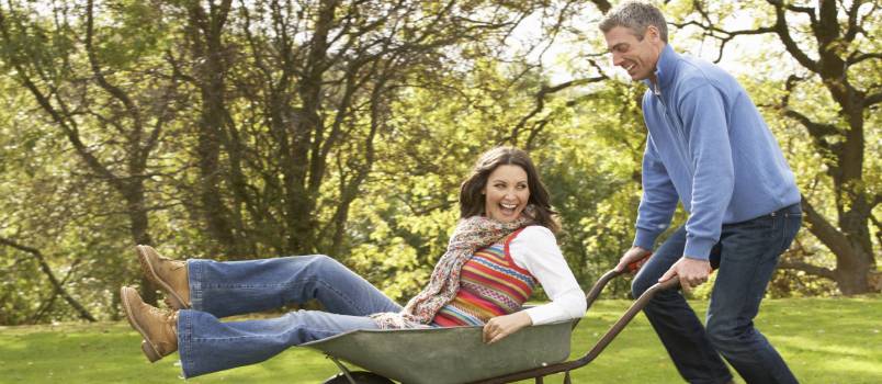 Man giving woman a ride in wheel board