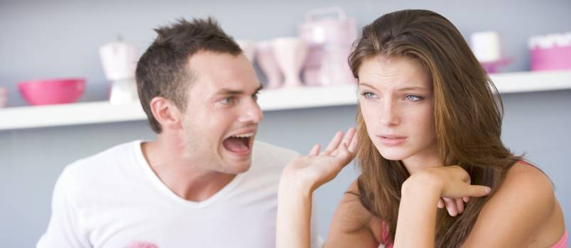 Young couple sitting at table arguing