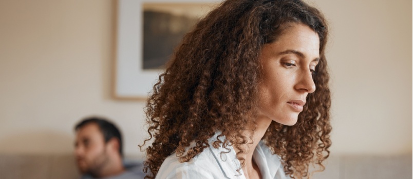 Depressed woman sitting in bedroom