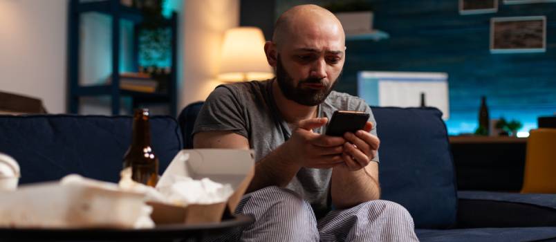 Unhappy depressed man using smartphone