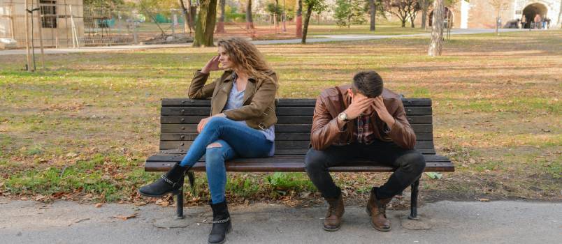 Depressed couple sitting outside