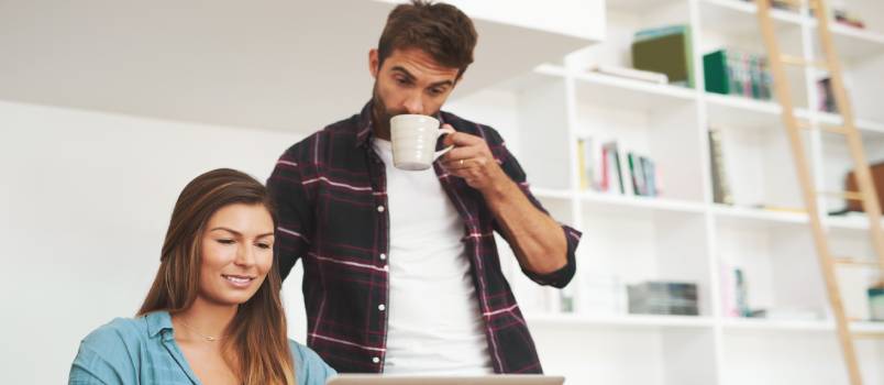 Young couple working on laptop while having coffee