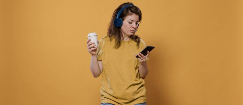 Woman using smartphone while having coffee