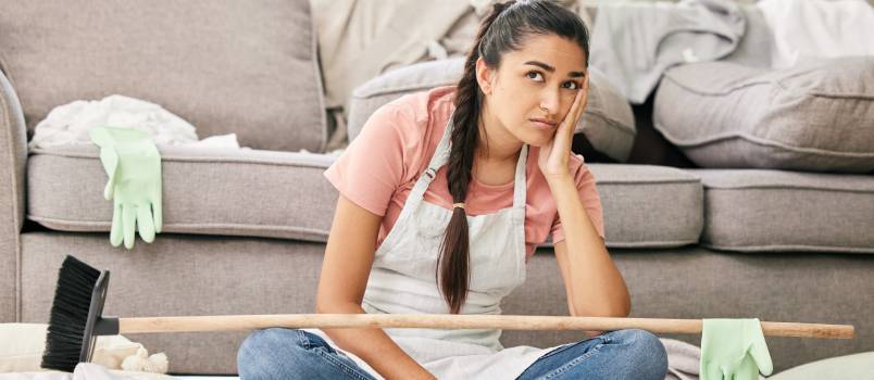 Woman sitting in messy living room