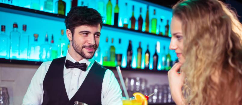 Handsome bartender flirting with woman