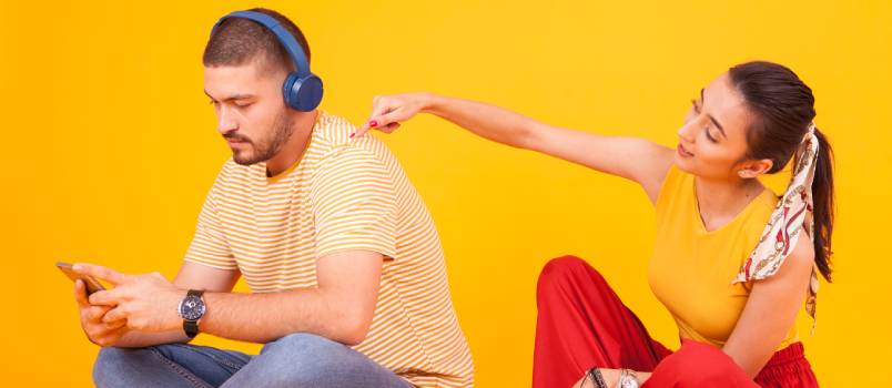 Boyfriend ignoring his girlfriend while using smartphone 