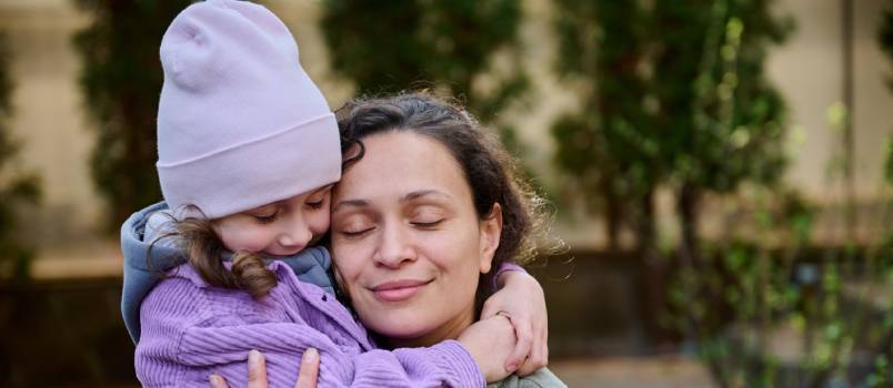 mother and daughter hugging each other in park