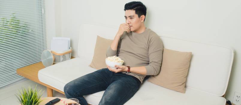 Bored asian man watching tv