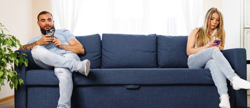 Couple using smartphone and ignoring each other