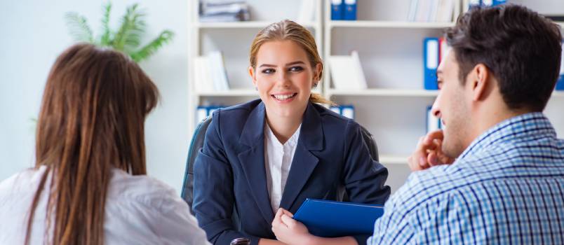 Family signing marriage document at lawyers office