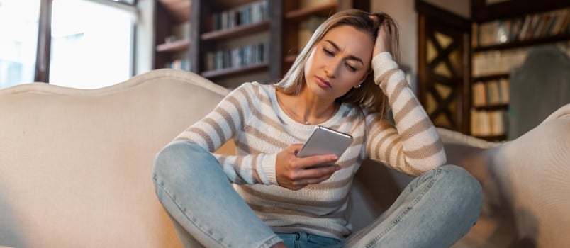 Sad woman texting on phone 