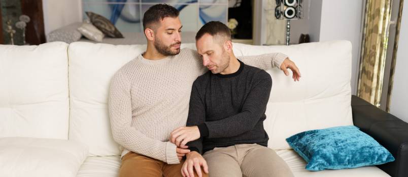 Gay couple chilling on sofa