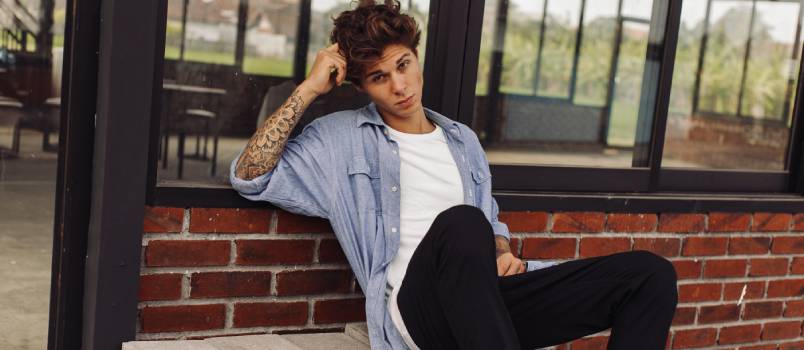 Young boy with tattoo siting on bricks