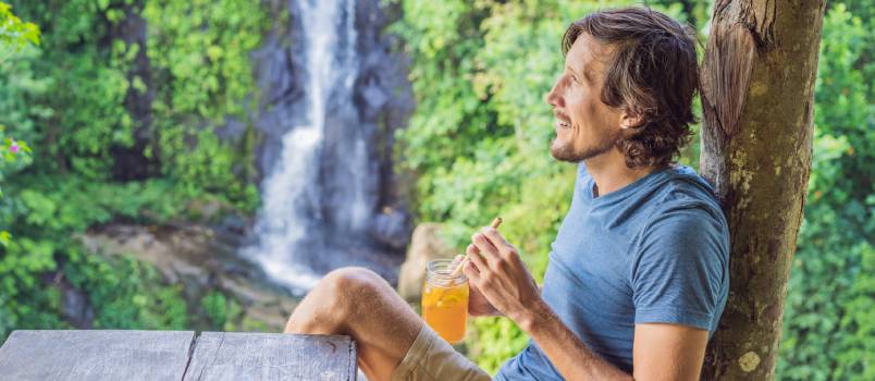 man enjoying ice tea in nature