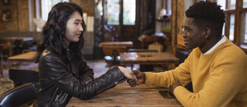 man and woman sitting holding their hands
