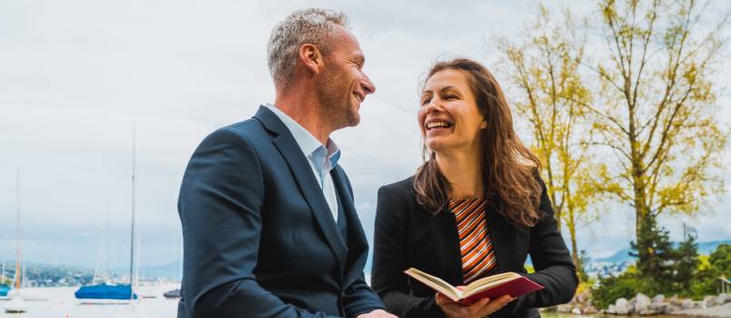 Happy couple reading book outside