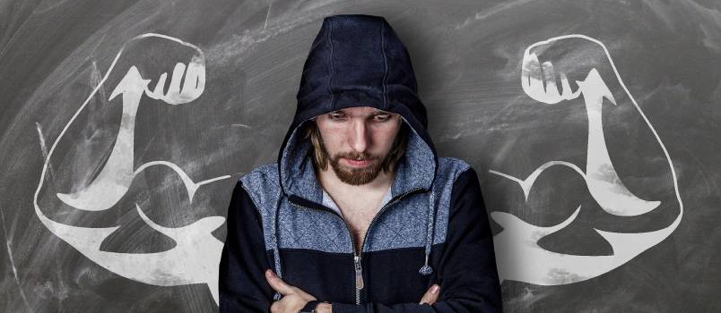 Bored man drawing muscles on wall